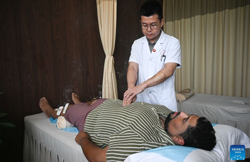 A foreigner experiences traditional Chinese medicine (TCM) therapy at Sanya International Friendship Sanatorium of TCM in Sanya, south China's Hainan Province, Aug. 26, 2026.
In recent years, thanks to the policies of the Hainan Free Trade Port, more international visitors have come to Sanya Hospital of TCM and its affiliated Sanya International Friendship Sanatorium of TCM to learn TCM techniques and experience TCM treatments.
As one of China's first national bases for exporting TCM services, the hospital and its affiliated sanatorium offer TCM treatments such as acupuncture, tuina massage and bone setting, while providing international training programs in TCM. In the first half of 2026, they received more than 8,000 international visitors.
Meanwhile, Sanya's TCM services are expanding overseas, with practitioners providing treatments and training in countries including Kazakhstan, France, Canada and Cabo Verde. TCM is becoming a distinctive link connecting Sanya with the world. Photo: Xinhua