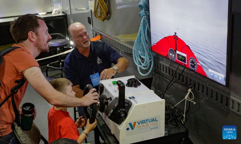 Visitors experience a maritime simulator during the Port Day event in Vancouver, British Columbia, Canada, Aug. 29, 2026. The annual event showcased the local maritime industry and its role in moving Canadian trade, featuring marine demonstrations and interactive exhibits that allowed the public to learn about local port operations and safety practices. (Photo by Liang Sen/Xinhua)