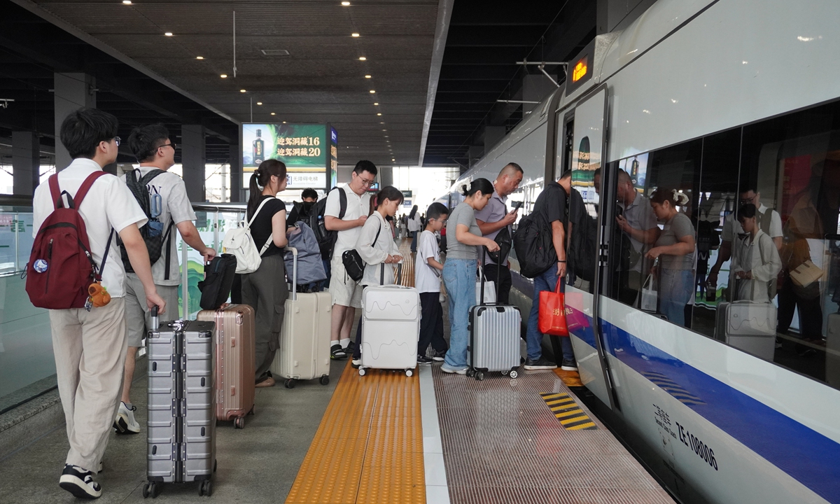 Amid a surge in travel during the peak summer return period, passengers board a bullet train at the Fuyang West Railway Station in Fuyang, East China's Anhui Province, on August 30, 2026.