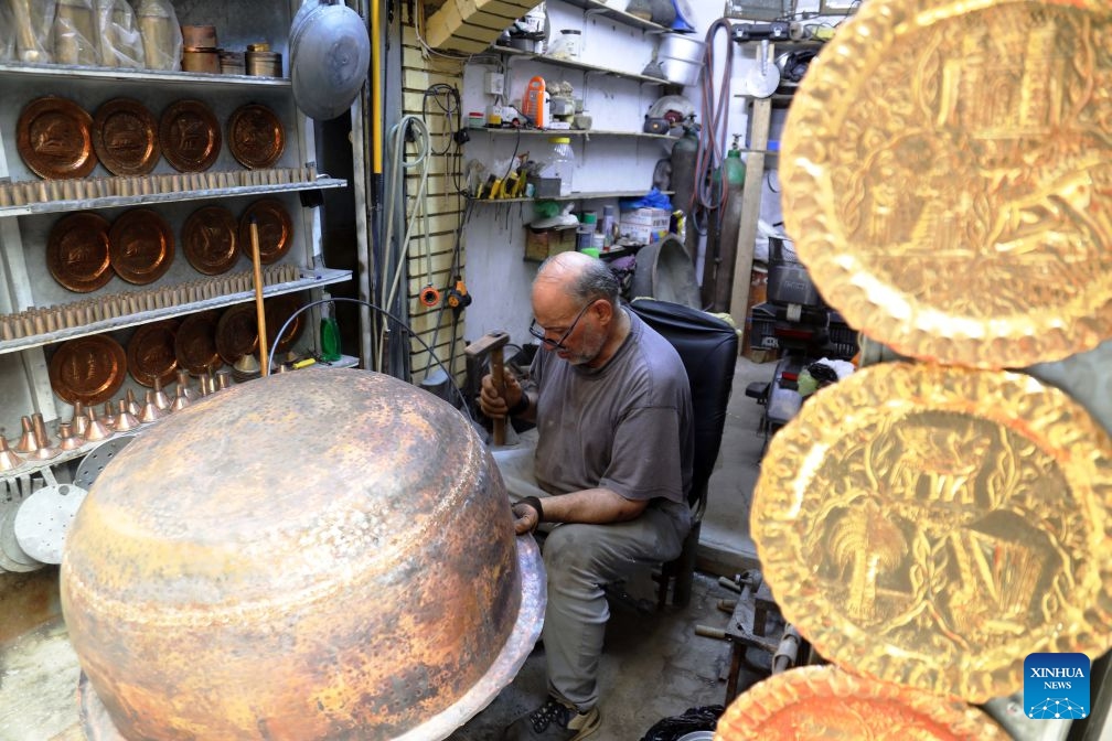 An artisan works on a copper item at Souk al-Safafeer, a traditional copper market, in Baghdad, Iraq, on Sept. 5, 2026. (Photo: Xinhua)