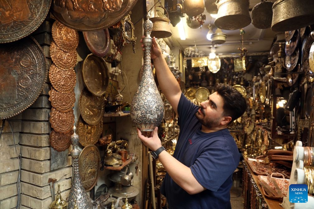 A man arranges copper items at Souk al-Safafeer, a traditional copper market, in Baghdad, Iraq, on Sept. 5, 2026. (Photo: Xinhua)