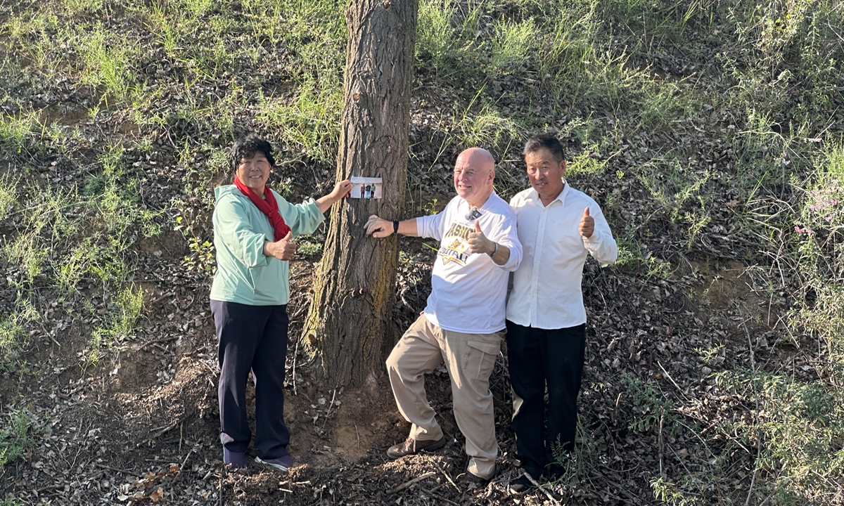 Yin Yuzhen (left), Ronald Sakolsky (center) and Yin's husband pose for a photo in front of a tree planted by Sakolsky 26 years ago, on August 24, 2026. Photo: Lin Xiaoyi/GT