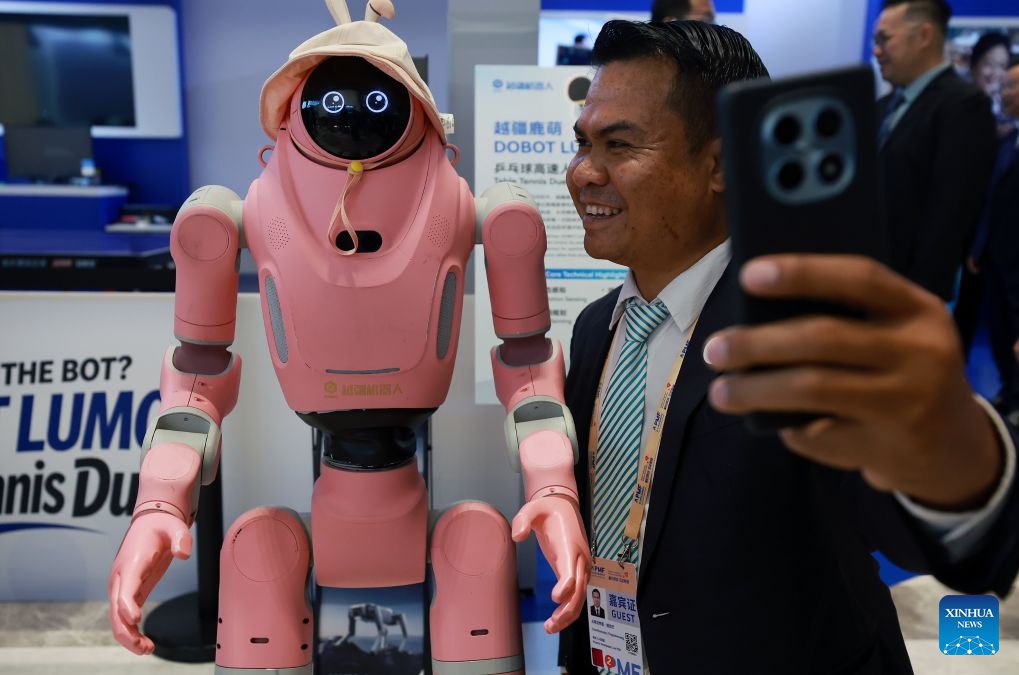 A visitor takes selfies with a robot during the Asia-Pacific Media Forum in Shenzhen, south China's Guangdong Province, Sept. 5, 2026. The Asia-Pacific Media Forum opened on Saturday in Shenzhen, with the theme of Building a Path to Shared Prosperity for the Asia-Pacific Community: Media Consensus and Action. The forum held an exhibition of scientific and technological innovation achievements, mainly showcasing cutting-edge innovation achievements in Guangdong Province, especially in Shenzhen. (Photo: Xinhua)