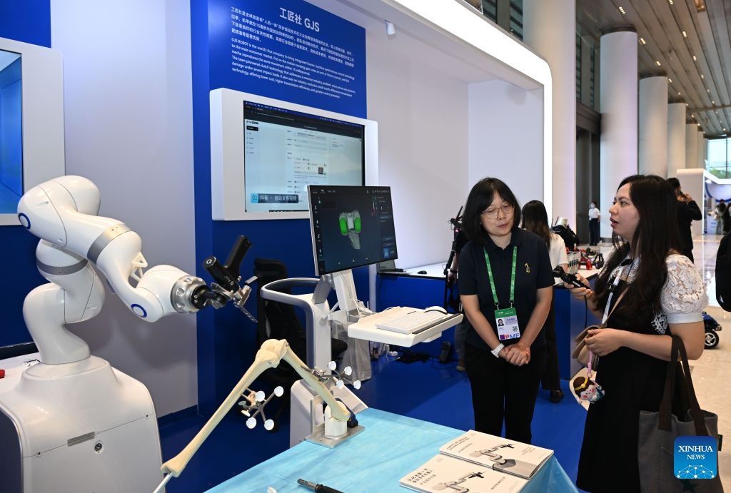 A staff member (L) introduces a surgical robot to a visitor during the Asia-Pacific Media Forum in Shenzhen, south China's Guangdong Province, Sept. 5, 2026. The Asia-Pacific Media Forum opened on Saturday in Shenzhen, with the theme of Building a Path to Shared Prosperity for the Asia-Pacific Community: Media Consensus and Action. The forum held an exhibition of scientific and technological innovation achievements, mainly showcasing cutting-edge innovation achievements in Guangdong Province, especially in Shenzhen. (Photo: Xinhua)