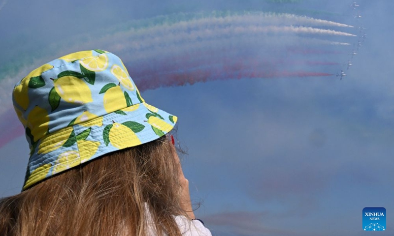 A spectator watches the Italian Frecce Tricolori aerobatic squad performing during an airshow flying over Lake Garda, Brescia, Italy, Sept. 4, 2026. (Photo: Xinhua)