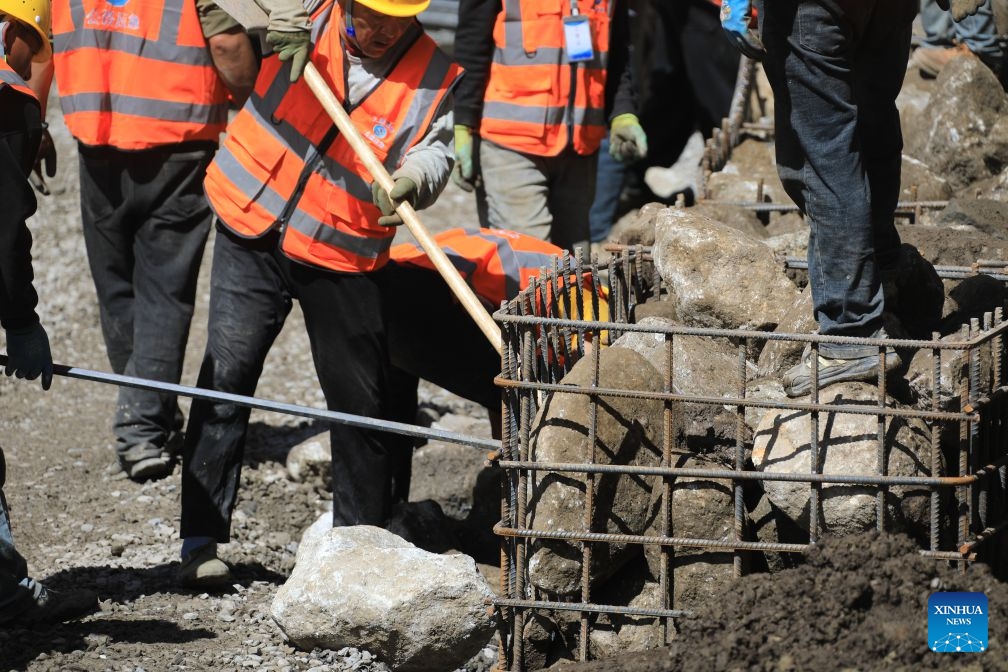Workers load stones for road-reinforcement at the core affected zone of the mudslide-hit Gyirong Port in southwest China's Xizang Autonomous Region, Sept. 5, 2026. More rescue forces have entered the core affected zone of the mudslide-hit Gyirong Port on Saturday. China Railway Group Limited have provided steel gabions to the site for road-reinforcement. (Photo: Xinhua)