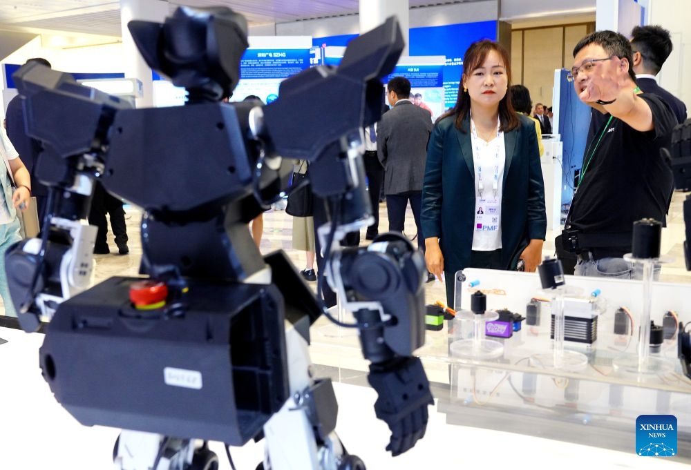 A staff member introduces a robot to a visitor during the Asia-Pacific Media Forum in Shenzhen, south China's Guangdong Province, Sept. 5, 2026. The Asia-Pacific Media Forum opened on Saturday in Shenzhen, with the theme of Building a Path to Shared Prosperity for the Asia-Pacific Community: Media Consensus and Action. The forum held an exhibition of scientific and technological innovation achievements, mainly showcasing cutting-edge innovation achievements in Guangdong Province, especially in Shenzhen. (Photo: Xinhua)