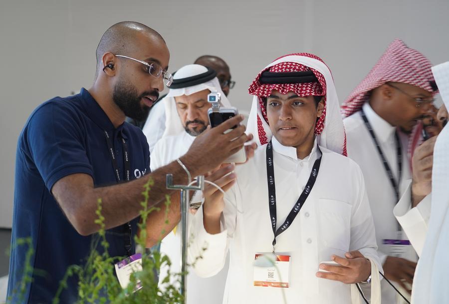 A staff member introduces the HONOR Robot Phone to a visitor at the LEAP 2026 Tech Conference in Riyadh, Saudi Arabia, Sept. 2, 2026. (Photo: Xinhua)
