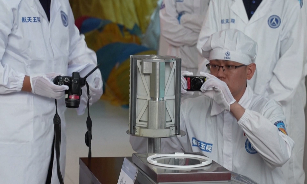Researchers photograph lunar soil samples at the capsule opening ceremony for the Chang'e-6 returner held at the China Academy of Space Technology in Beijing on June 26, 2024. Photo: VCG