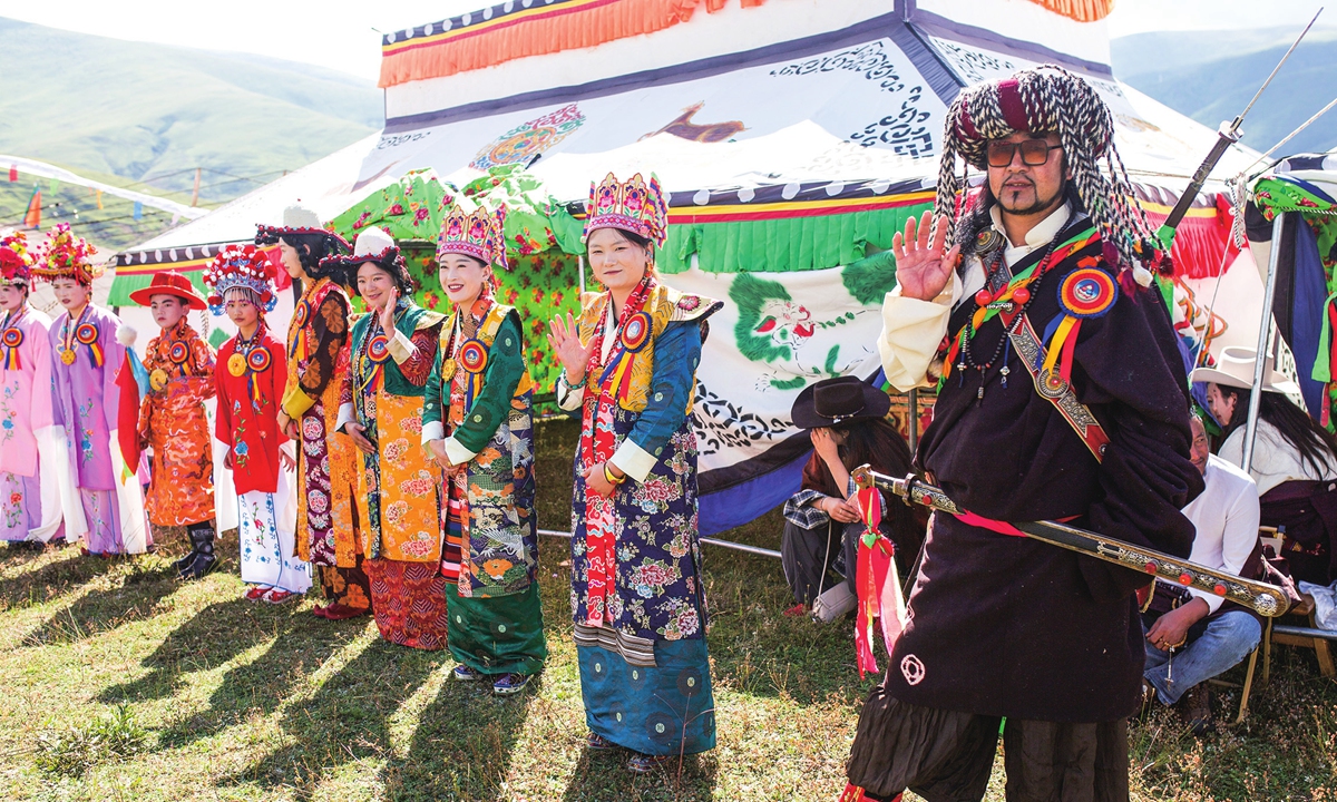 People in Tibetan costumes wave to visitors in Taining town, Dawu County, on August 29, 2026. Photo: Shan Jie/GT
