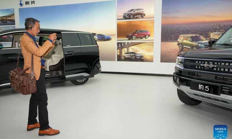 A guest takes photos of a BYD car in the exhibition hall at BYD's headquarters in Shenzhen, south China's Guangdong Province, Sept. 4, 2026.(Xinhua/Dai Mingxuan)

