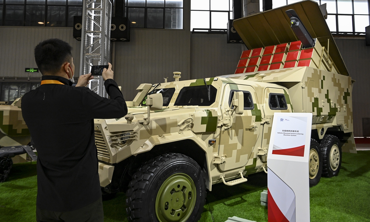 A man takes photos of a light high mobility vehicle-mounted drone swarm weapon system at Airshow China in Zhuhai, South China's Guangdong Province. File photo: VCG