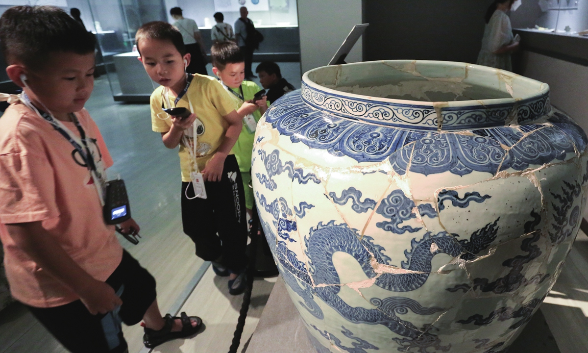 An oracle bone inscription from the Shang Dynasty  Children look at a fully restored Ming Dynasty 