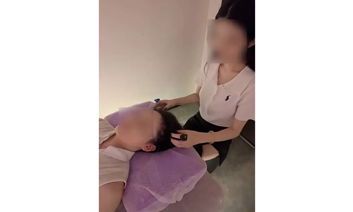 A customer receives scratching services at Zhang's shop in Shenzhen, South China's Guangdong Province. Photo: Jimu News