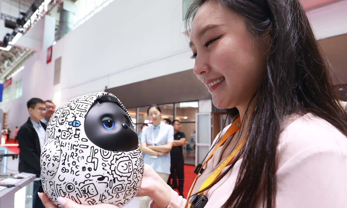 A visitor checks on the AI-powered companion robot  Photo: VCG