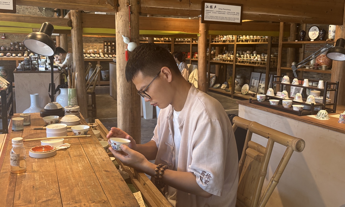A local craftman draws patterns on a porcelain. Photo: Li Hang/GT