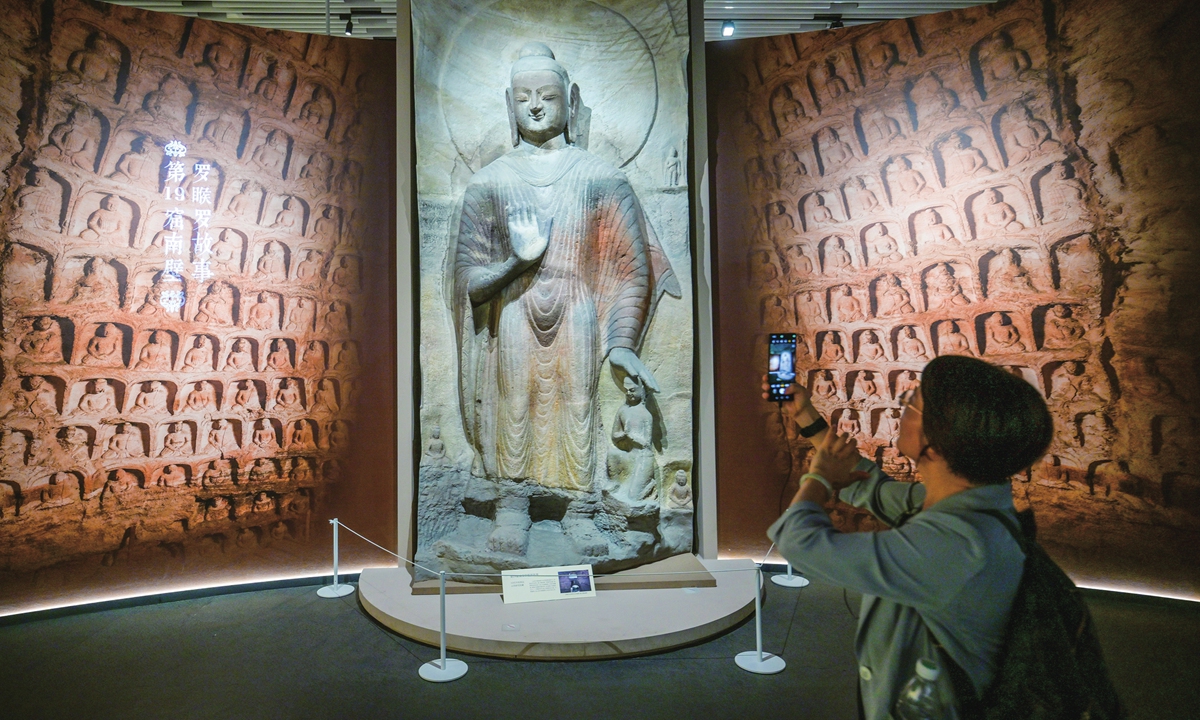 A visitor takes photos at the Yungang Grottoes special exhibition hosted at the Sanxingdui Museum in Guanghan, Southwest China's Sichuan Province, on September 8, 2026. More than 120 sets of cultural relics and art replicas from the Yungang Grottoes in Datong, North China's Shanxi Province, are on display, showcasing the grotto art, history and cultural heritage of the Northern Wei Dynasty (386-534). Photo: VCG