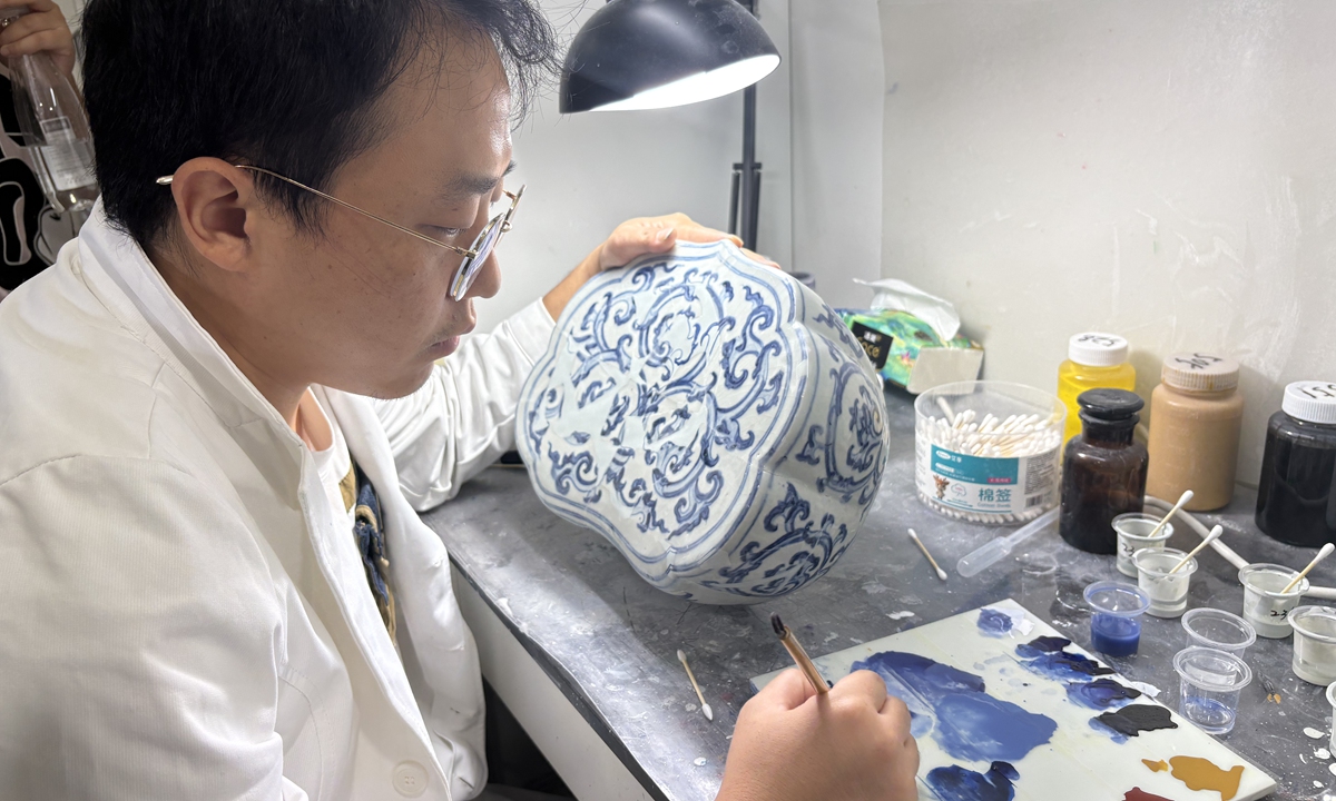 A restorer repaires a piece of porcelain. Photo: Li Hang/GT