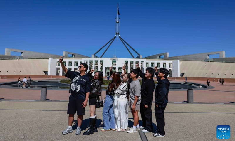 Tourists pose for selfies in front of the Australian Parliament House in Canberra, Australia, on Sept. 12, 2026. Australia recorded 710,980 short-term visitor arrivals in July 2026, down 4.3 percent from the same month a year earlier, official data showed on Friday. (Photo by Chu Chen/Xinhua)