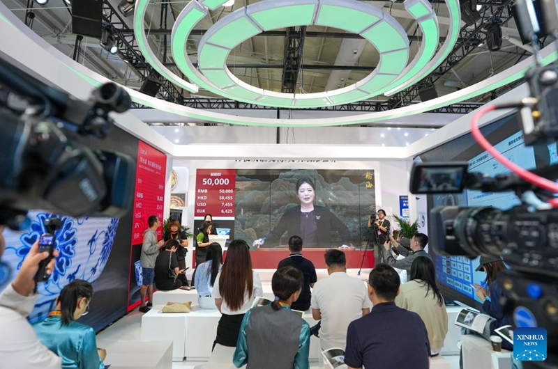 People attend an auction of artworks at the themed exhibition area for culture and tourism services during the 2026 China International Fair for Trade in Services (CIFTIS) at Shougang Park in Beijing, capital of China, Sept. 12, 2026. The 2026 CIFTIS, running from Sept. 9 to 13 at Shougang Park in Beijing, has brought together 413 exhibitors at the themed exhibition area for culture and tourism services, showcasing emerging models of cultural and tourism integration. (Xinhua/Ju Huanzong)