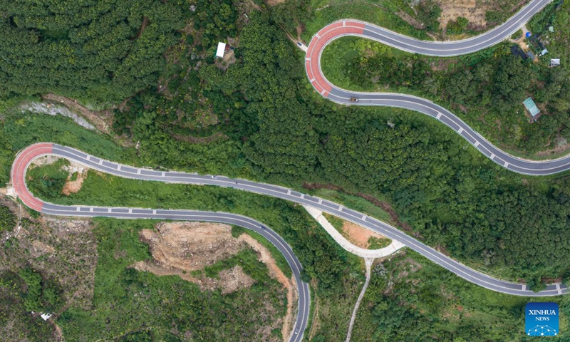 An aerial drone photo taken on Aug. 22, 2026 shows a view of a scenic ring road surrounding the Hainan Tropical Rainforest National Park in Baoting Li and Miao Autonomous County, south China's Hainan Province. The scenic ring road surrounding the Hainan Tropical Rainforest National Park passes through nine cities and counties in Hainan, including Lingshui, Baoting, Ledong and Changjiang, with a total length of 466 kilometers. The ring road was officially opened to traffic in December 2024.
This road connects the beautiful scenery of the mountainous areas in the central and southern parts of Hainan Island and builds a green corridor that balances ecological protection and cultural tourism development.
At present, many tourists come to cycle and drive on the road, boosting tourism-related consumption including accommodation, catering, specialty agricultural products, and outdoor culture and tourism along the road. Photo: Xinhua