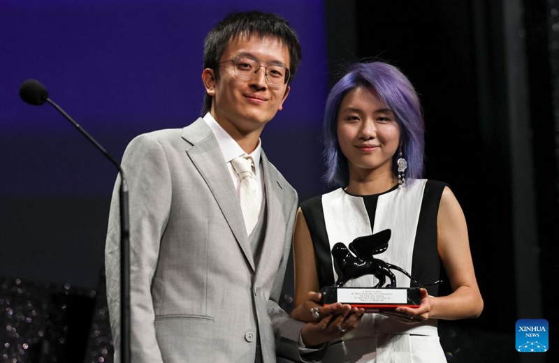 Director Zhang Yuqi (R) and director Tao Shixin of the short film The Pigeon Ring pose with the trophy during the awarding ceremony of the 83rd Venice International Film Festival in Venice, Italy, Sept. 12, 2026. Chinese short film The Pigeon Ring won the Venice Immersive Grand Prize, the top award of the Venice Immersive section, at the 83rd Venice International Film Festival on Saturday. (Xinhua/Wang Kaiyan)