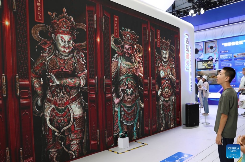 A kid experiences an interactive digital device at the themed exhibition area for culture and tourism services during the 2026 China International Fair for Trade in Services (CIFTIS) at Shougang Park in Beijing, capital of China, Sept. 12, 2026. The 2026 CIFTIS, running from Sept. 9 to 13 at Shougang Park in Beijing, has brought together 413 exhibitors at the themed exhibition area for culture and tourism services, showcasing emerging models of cultural and tourism integration. (Photo by Ma Zihan/Xinhua)