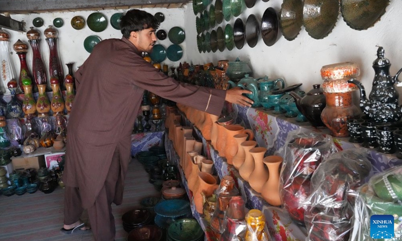 A shopkeeper arranges traditional pottery and ceramic products at a shop in Kabul, Afghanistan, Sept. 13, 2026. (Photo by Saifurahman Safi/Xinhua)

