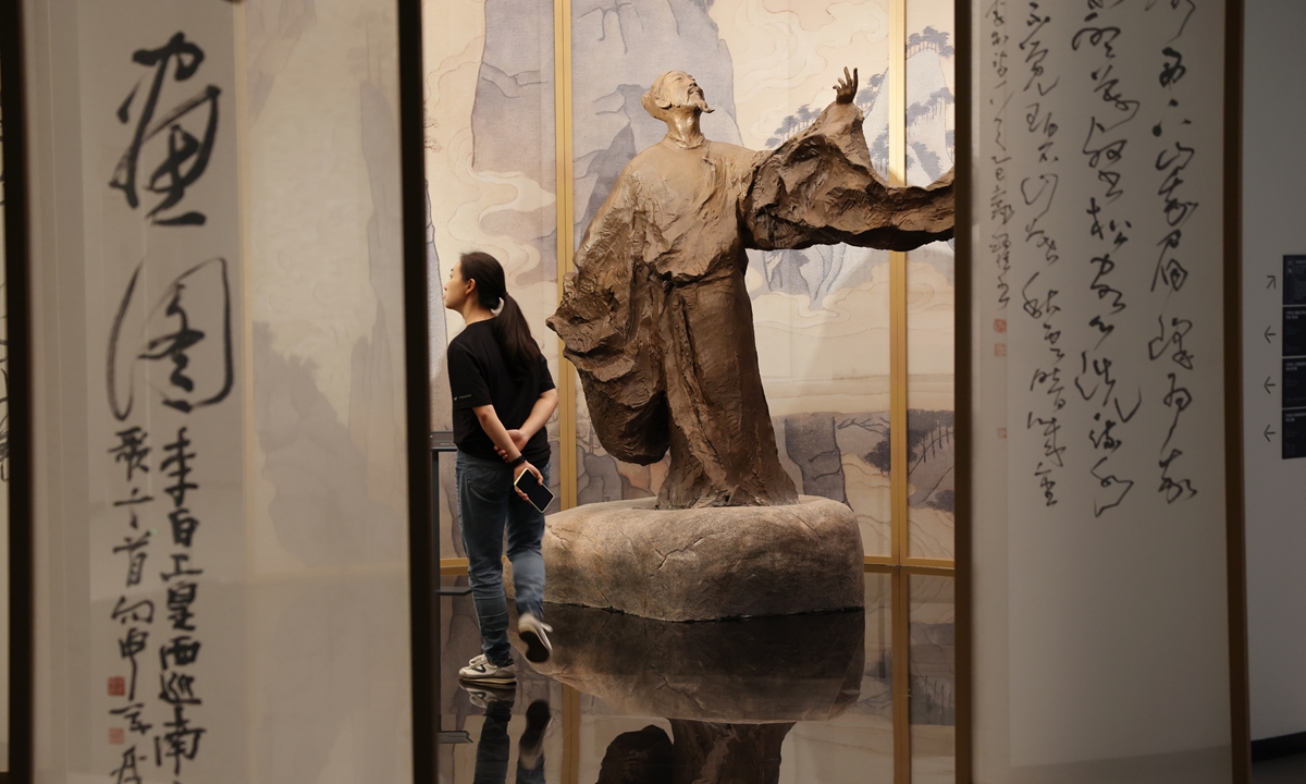 A visitor explores the newly opened Sichuan Hall of Fame beside a bronze statue of Tang Dynasty (618-907) poet Li Bai in Chengdu, Southwest China's Sichuan Province, on September 17, 2026. The museum features a total of 70 historical figures from Sichuan dating back to the pre-Qin period (before 221BC), covering politics, military affairs, education, literature, science and technology and other fields. Photo: VCG