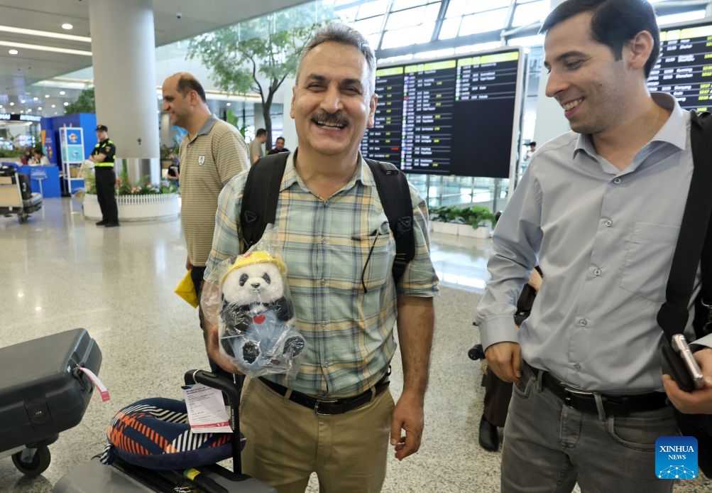 A member of Iranian delegation for the 48th WorldSkills Competition (L) shows a doll panda he has just bought upon his arrival at Shanghai Pudong International Airport in Shanghai, east China, Sept. 17, 2026. The 48th WorldSkills Competition is scheduled to take place from September 22 to 27 in Shanghai. (Photo: Xinhua)