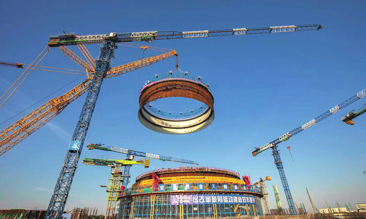 Workers lift the containment top ring onto the top of a reactor building at the Xuwei nuclear energy heating and power plant in Lianyungang, East China's Jiangsu Province.
