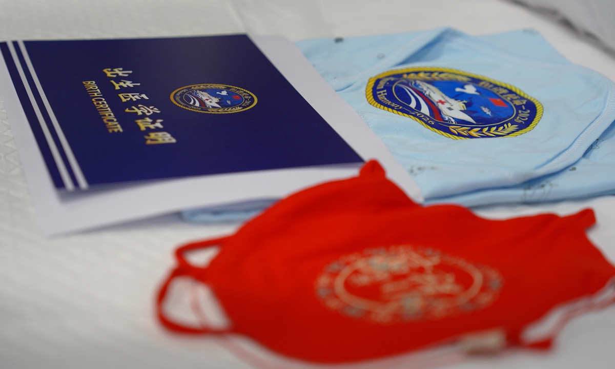 A traditional Chinese-style red bellyband and a blanket bearing the words 