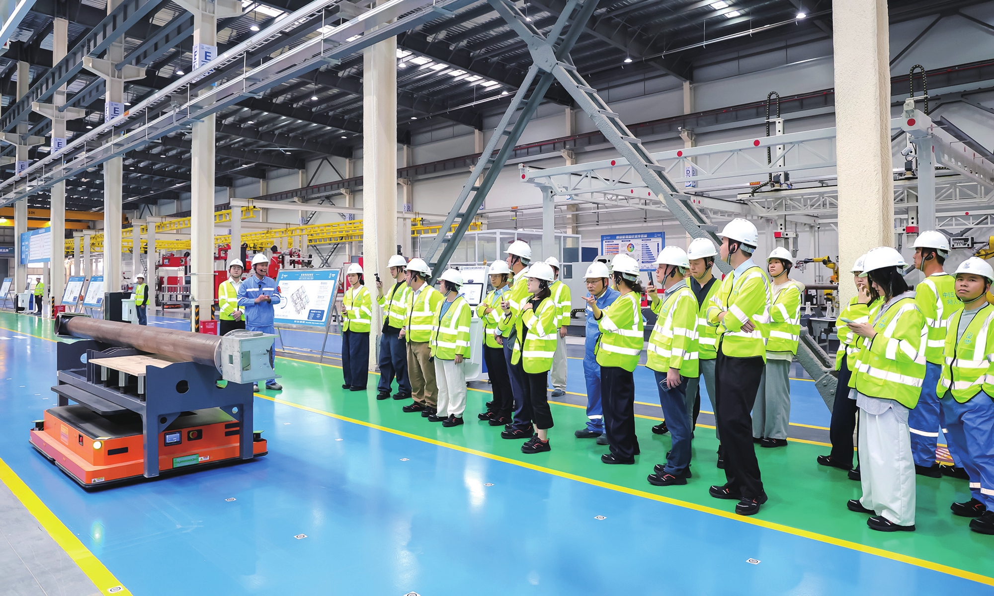 An AI-controlled automated guided vehicle carries a pipe as visitors tour the nuclear power intelligent manufacturing base in Qidong, Shanghai.