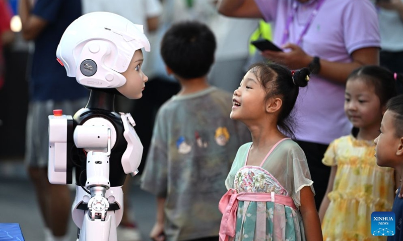 A girl talks with a humanoid robot at the 23rd China-ASEAN Expo in Nanning, south China's Guangxi Zhuang Autonomous Region, Sept. 19, 2026. Multiple intelligent robots were showcased and demonstrated a variety of skills at the China-ASEAN Expo. (Xinhua/Huang Xiaobang)