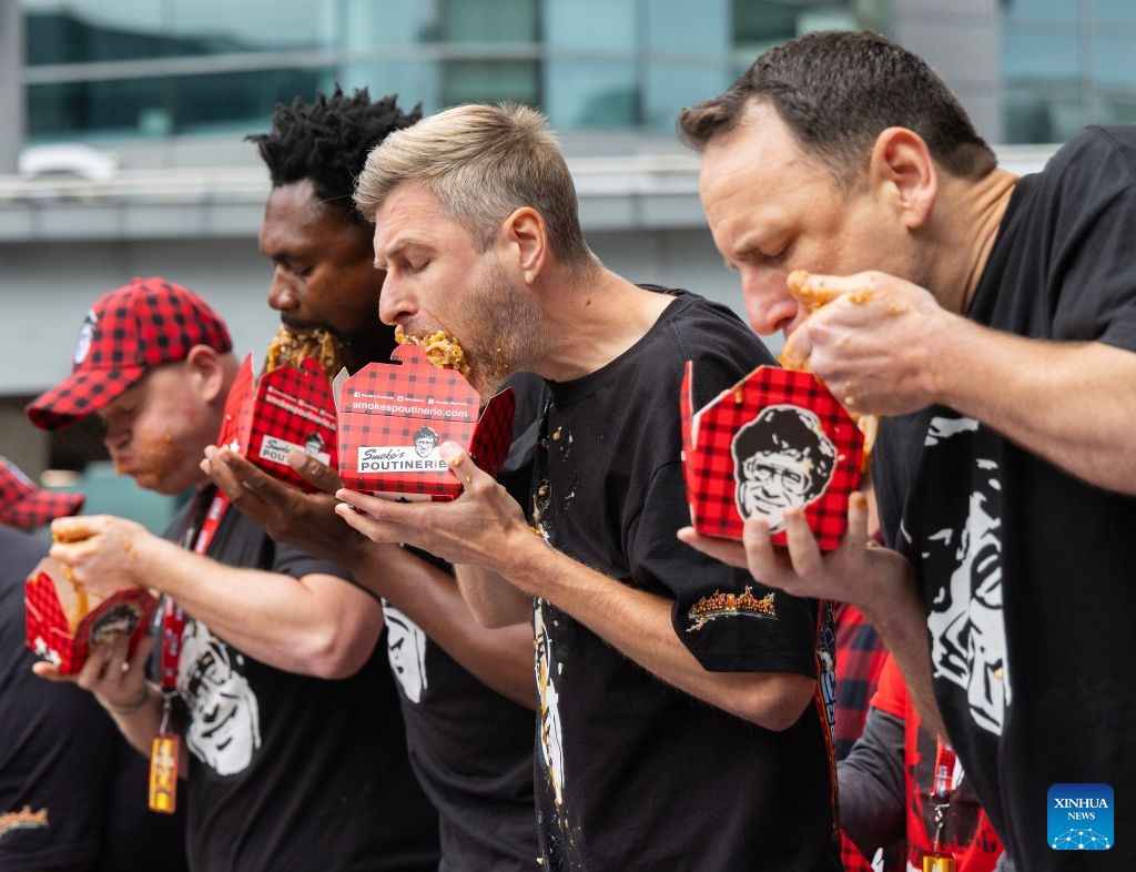 Contestants compete during the 2026 World Poutine Eating Championship in Toronto, Canada, on Sept. 19, 2026. The annual event took place in Toronto on Saturday, with 13 competitive eaters. Joey Chestnut of the United States claimed the title after eating 21.25 pounds of poutine in 10 minutes. (Photo by Zou Zheng/Xinhua)