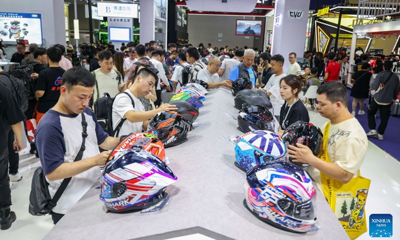 Visitors view motorcycle helmets at the 24th China International Motorcycle Trade Exhibition in Chongqing, southwest China, Sept. 19, 2026. The 24th China International Motorcycle Trade Exhibition is held in Chongqing from Sept. 19 to 22. (Xinhua/Huang Wei)