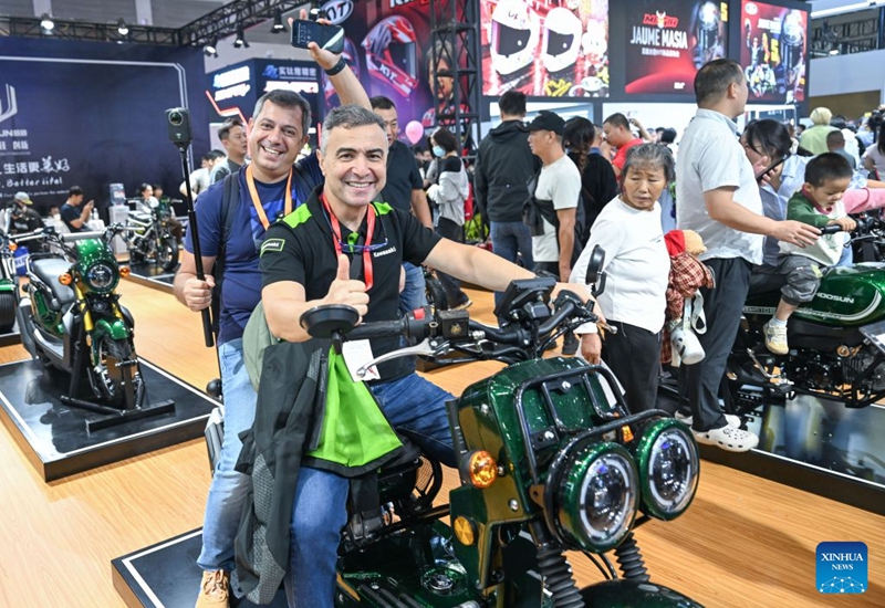 Foreign visitors pose for photos at the 24th China International Motorcycle Trade Exhibition in Chongqing, southwest China, Sept. 19, 2026. The 24th China International Motorcycle Trade Exhibition is held in Chongqing from Sept. 19 to 22. (Xinhua/Chen Cheng)