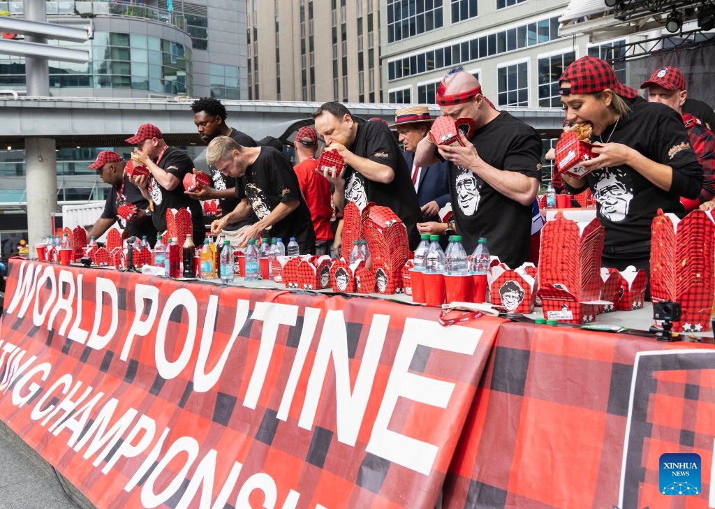 Contestants compete during the 2026 World Poutine Eating Championship in Toronto, Canada, on Sept. 19, 2026. The annual event took place in Toronto on Saturday, with 13 competitive eaters. Joey Chestnut of the United States claimed the title after eating 21.25 pounds of poutine in 10 minutes. (Photo by Zou Zheng/Xinhua)
