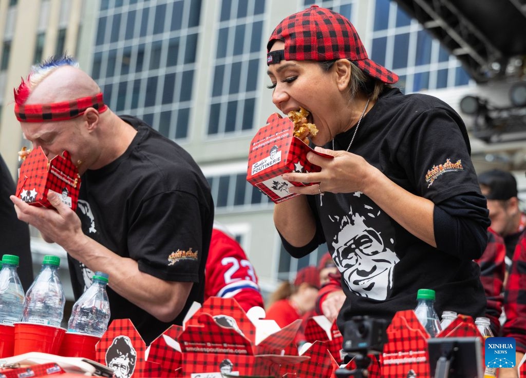 Contestants compete during the 2026 World Poutine Eating Championship in Toronto, Canada, on Sept. 19, 2026. The annual event took place in Toronto on Saturday, with 13 competitive eaters. Joey Chestnut of the United States claimed the title after eating 21.25 pounds of poutine in 10 minutes. (Photo by Zou Zheng/Xinhua)