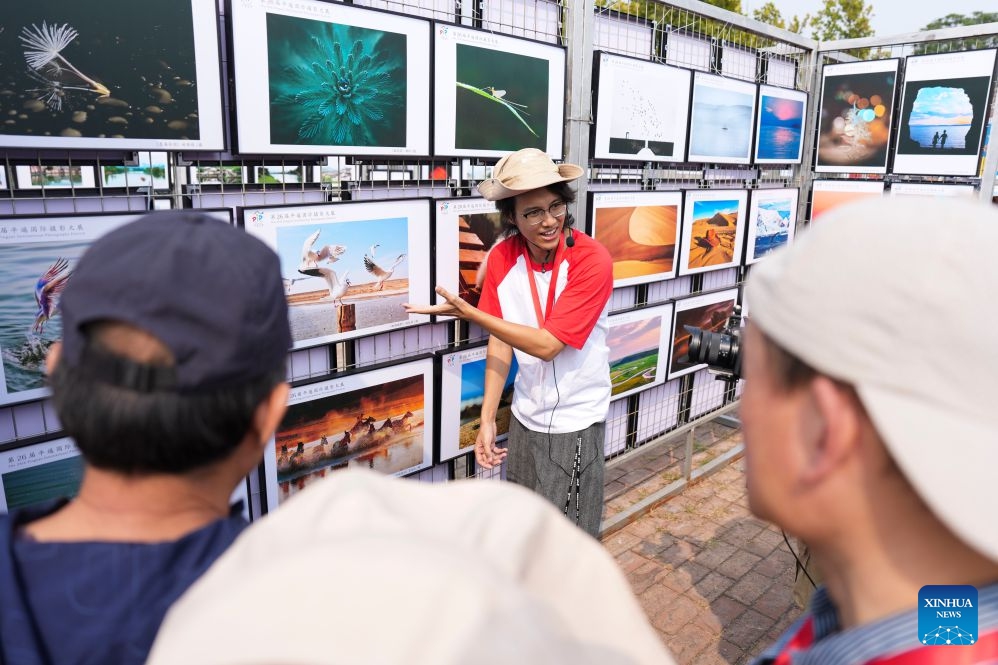 A photographer introduces works to visitors at the 26th Pingyao International Photography Festival (PIP) in Pingyao ancient town in Jinzhong, north China's Shanxi Province, Sept. 19, 2026. The 26th PIP kicked off here on Saturday, featuring works by more than 2,600 photographers from over 30 countries and regions. The event will run until Sept. 23. (Xinhua/Yang Chenguang)