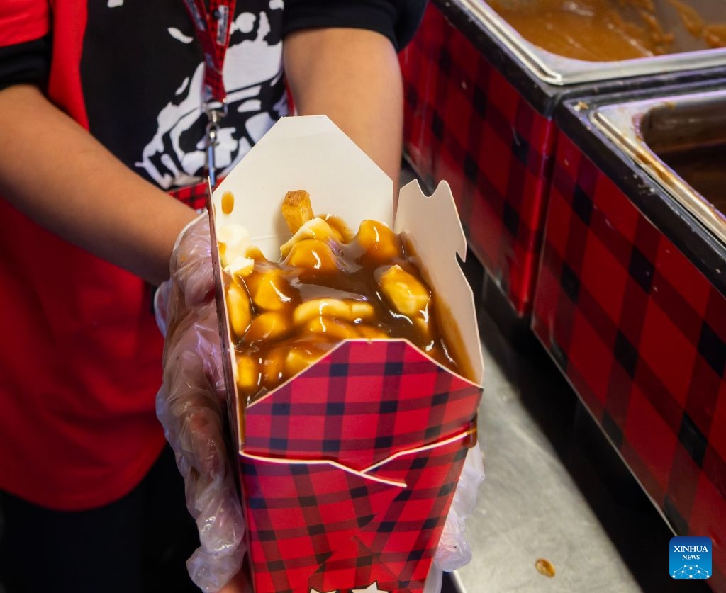 A staff member shows a serving of poutine after the 2026 World Poutine Eating Championship in Toronto, Canada, on Sept. 19, 2026. The annual event took place in Toronto on Saturday, with 13 competitive eaters. Joey Chestnut of the United States claimed the title after eating 21.25 pounds of poutine in 10 minutes. (Photo by Zou Zheng/Xinhua)
