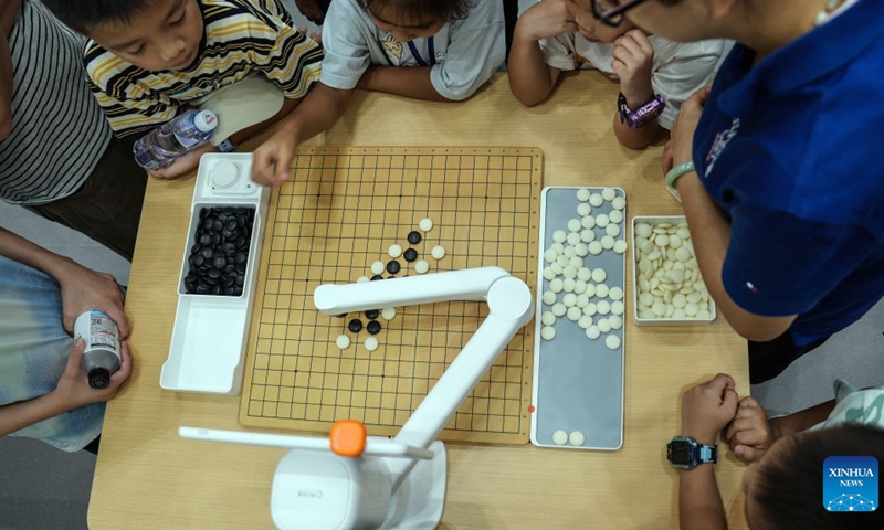 A robot plays Go game, known as Weiqi in Chinese, with children at the 23rd China-ASEAN Expo in Nanning, south China's Guangxi Zhuang Autonomous Region, Sept. 19, 2026. Multiple intelligent robots were showcased and demonstrated a variety of skills at the China-ASEAN Expo. (Xinhua/Zhang Ailin)