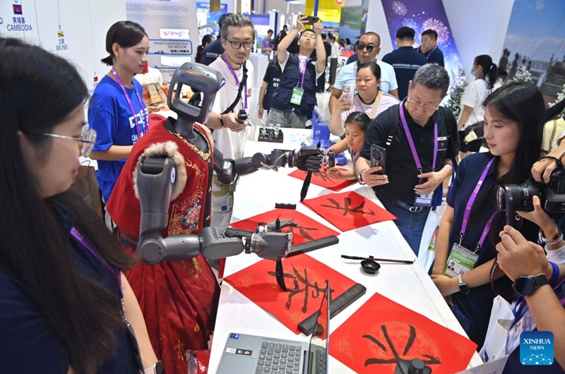 A humanoid robot writes Chinese calligraphy at the 23rd China-ASEAN Expo in Nanning, south China's Guangxi Zhuang Autonomous Region, Sept. 18, 2026. Multiple intelligent robots were showcased and demonstrated a variety of skills at the China-ASEAN Expo. (Xinhua/Zhou Hua)