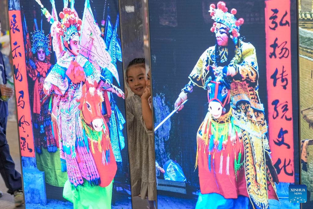 A girl visits the 26th Pingyao International Photography Festival (PIP) in Pingyao ancient town in Jinzhong, north China's Shanxi Province, Sept. 19, 2026. The 26th PIP kicked off here on Saturday, featuring works by more than 2,600 photographers from over 30 countries and regions. The event will run until Sept. 23. (Xinhua/Yang Chenguang)