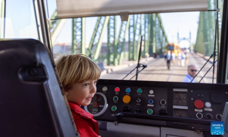 A child visits the interior of a tram during a car-free weekend event in Budapest, Hungary, on Sept. 19, 2026. Budapest is holding a car-free weekend on Sept. 19-20 as part of European Mobility Week, promoting environmentally friendly and sustainable travel through public transport vehicle displays, cycling activities and family events. (Xinhua/Hu Zhixuan)