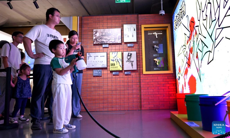 A visitor plays a spray-paint mural game at the WorldSkills Museum in east China's Shanghai, Sept. 19, 2026. With the 48th WorldSkills Competition approaching, the WorldSkills Museum is drawing growing attention. Visitors can learn about the history of the competition and traditional Chinese craftsmanship, and play interactive games based on competition events. (Xinhua/Fang Zhe)