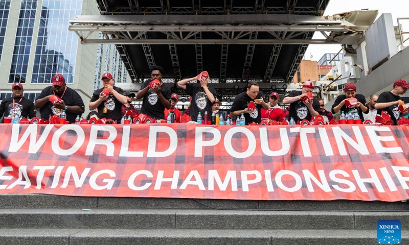 Contestants compete during the 2026 World Poutine Eating Championship in Toronto, Canada, on Sept. 19, 2026. The annual event took place in Toronto on Saturday, with 13 competitive eaters. Joey Chestnut of the United States claimed the title after eating 21.25 pounds of poutine in 10 minutes. (Photo by Zou Zheng/Xinhua)