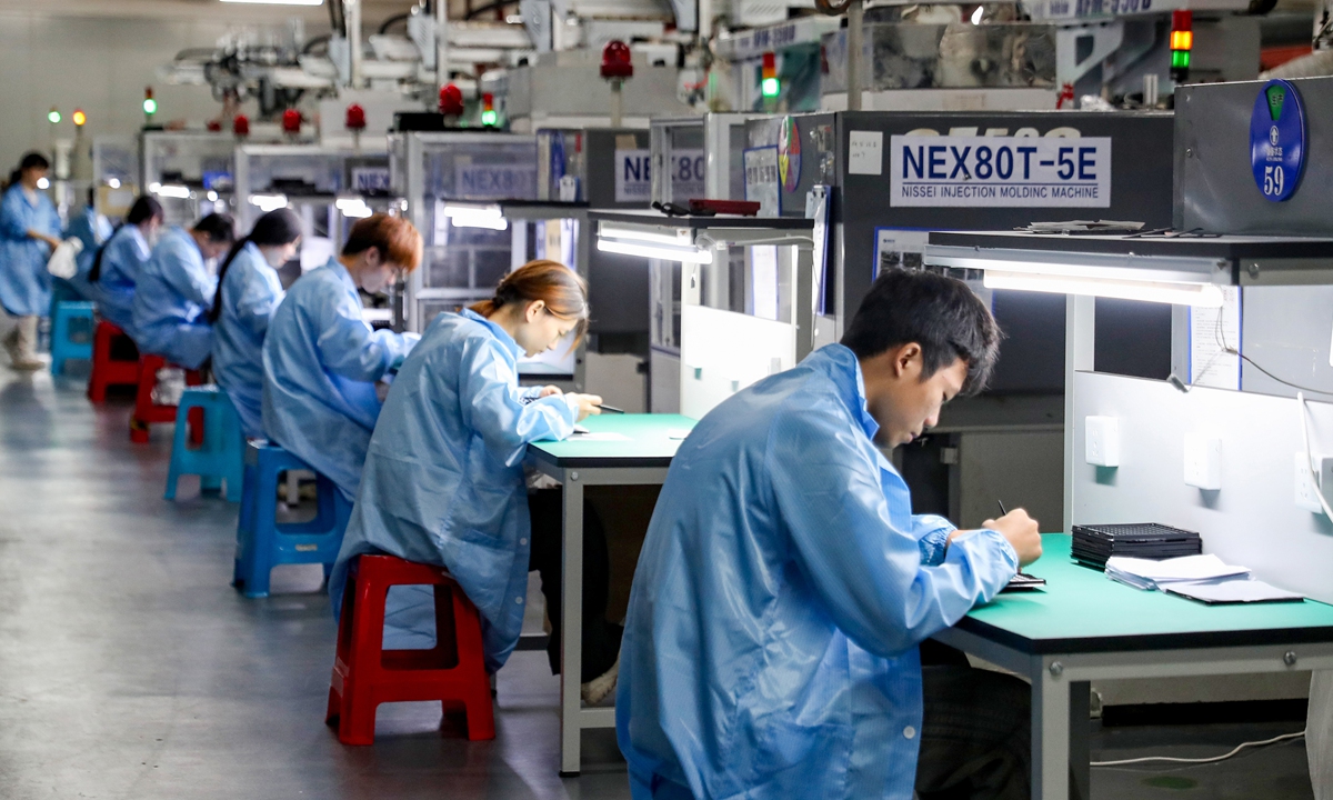 Workers inspect products made with intelligent equipment at a smart workshop in Huaying, Southwest China's Sichuan Province, on September 20, 2026. The city is promoting new quality productive forces by expanding the use of industrial robots, artificial intelligence and other technologies. Photo: VCG