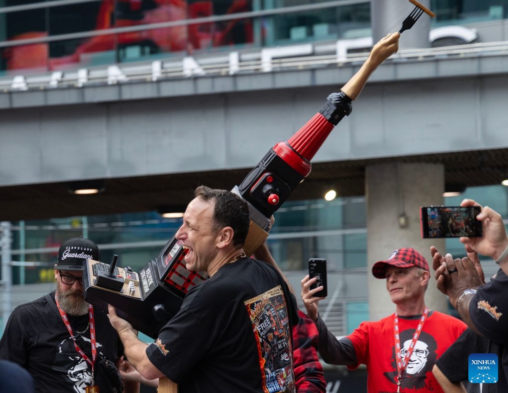 Joey Chestnut (front) of the United States celebrates his victory with the trophy after the 2026 World Poutine Eating Championship in Toronto, Canada, on Sept. 19, 2026. The annual event took place in Toronto on Saturday, with 13 competitive eaters. Joey Chestnut of the United States claimed the title after eating 21.25 pounds of poutine in 10 minutes. (Photo by Zou Zheng/Xinhua)