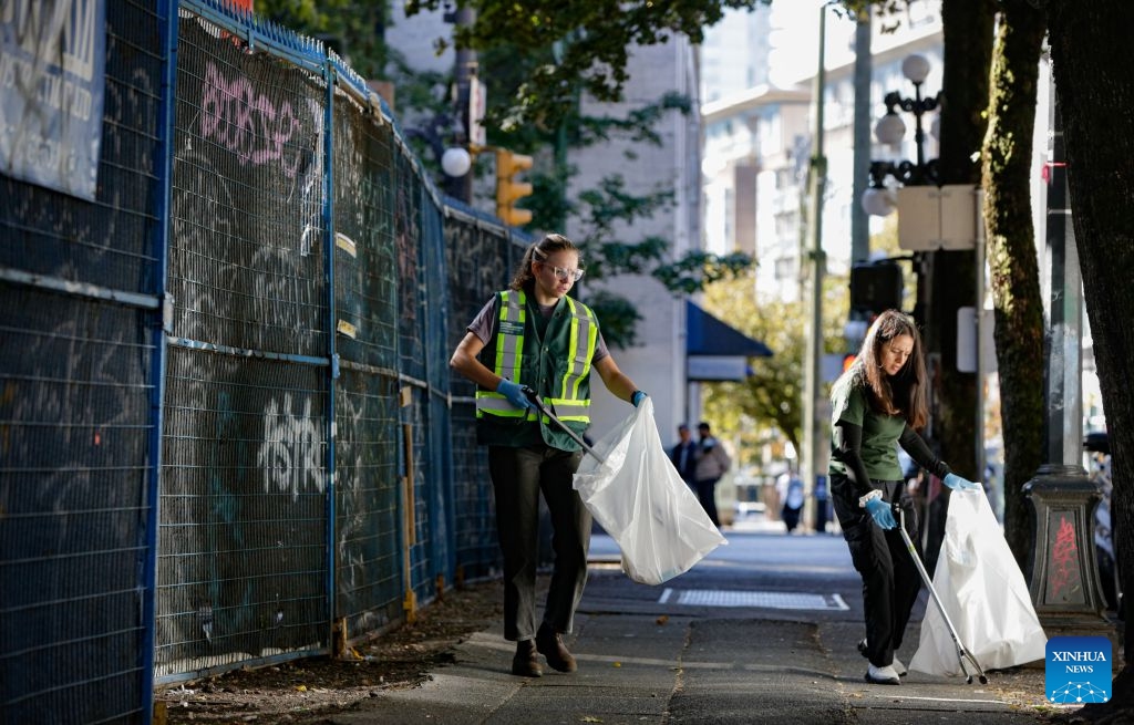 Volunteers collect garbage from a street to mark World Cleanup Day in Vancouver, British Columbia, Canada, Sept. 20, 2026. Volunteers teamed up to clean up streets in downtown Vancouver on Sunday to mark World Cleanup Day, a global environmental event observed annually on Sept. 20. (Photo by Liang Sen/Xinhua)